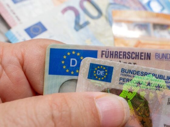 German ID card and driver’s license in hand, EU flag, Modern European driving permit, identification and travel, personal card and license, EU citizen travel, Frankfurt - July 9, 2025